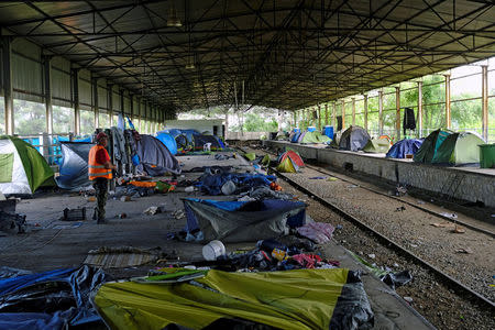 A worker stands next to empty tents during a police operation to evacuate a migrants' makeshift camp at the Greek-Macedonian border near the village of Idomeni, Greece, May 26, 2016. REUTERS/Marko Djurica