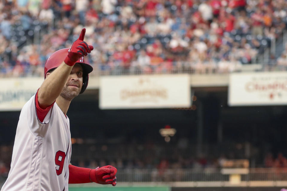 Washington Nationals' Brian Dozier gestures after hitting a solo home run during the second inning of the team's baseball game against the Chicago Cubs, Saturday, May 18, 2019, in Washington. (AP Photo/Andrew Harnik)