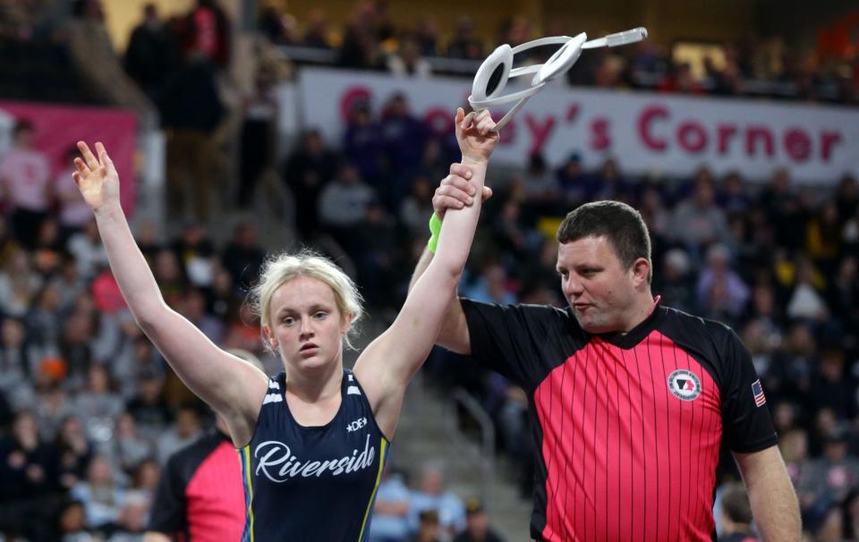 A referee raises Riverside’s Molly Allen’s hand after she won her opening match at the IGHSAU girls state wrestling tournament Thursday, Feb. 1, 2024 at Xtream Arena in Coralville.