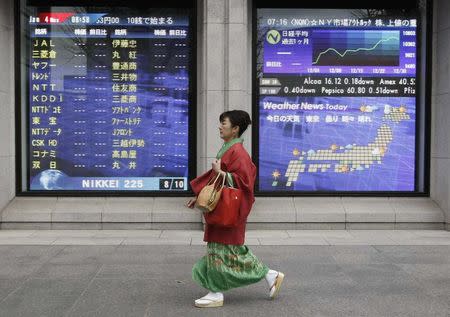 A woman in kimono walks past a stock quotation board outside a brokerage in Tokyo, in this January 4, 2010 file photo. REUTERS/Toru Hanai/Files