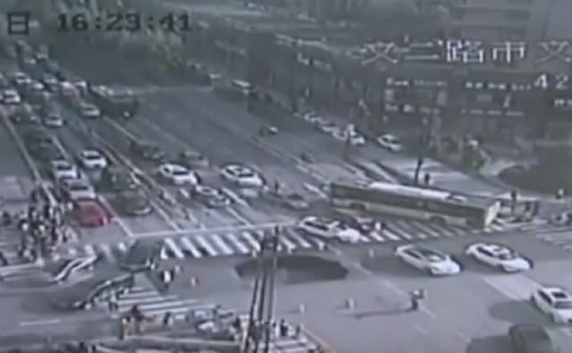 Watch as huge sinkhole opens up in middle of busy road