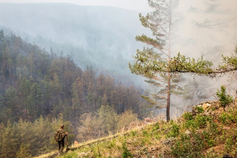 A Russian forest ranger inspects a burning valley on Olkhon island, the largest island in Lake Baikal in eastern Siberia, where abnormally hot and dry weather this summer has left forests tinder-dry