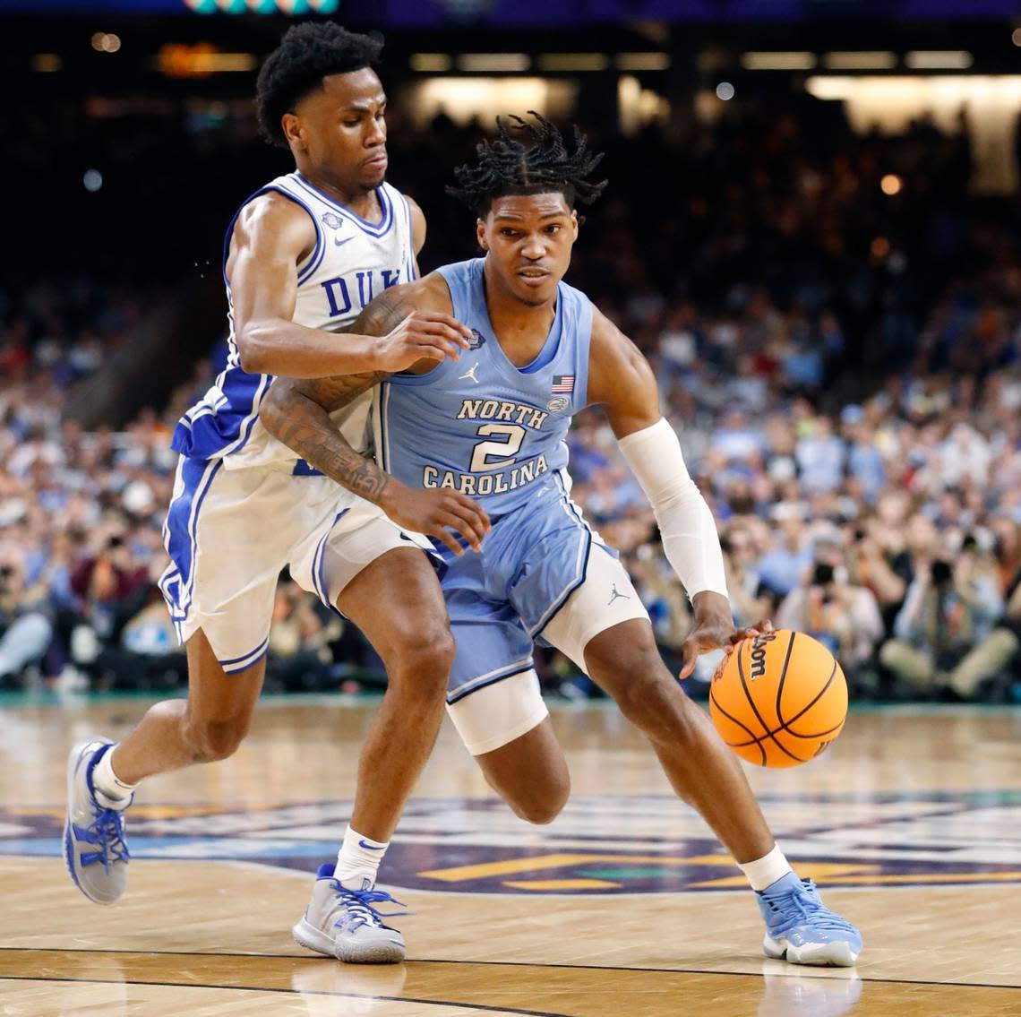North Carolina’s Caleb Love (2) drives around Dukes Jeremy Roach (3) during the first half of Dukes game against UNC in the Final Four at Caesars Superdome in New Orleans, La., Saturday, April 2, 2022.