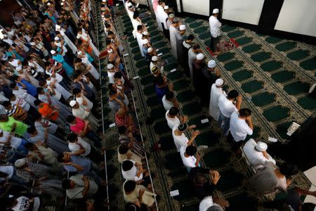 Muslims perform Eid al-Fitr prayers at a mosque inside city hall compound as government forces continue their assault against insurgents from the Maute group, who have taken over large parts of Marawi City, Philippines June 25, 2017. REUTERS/Jorge Silva