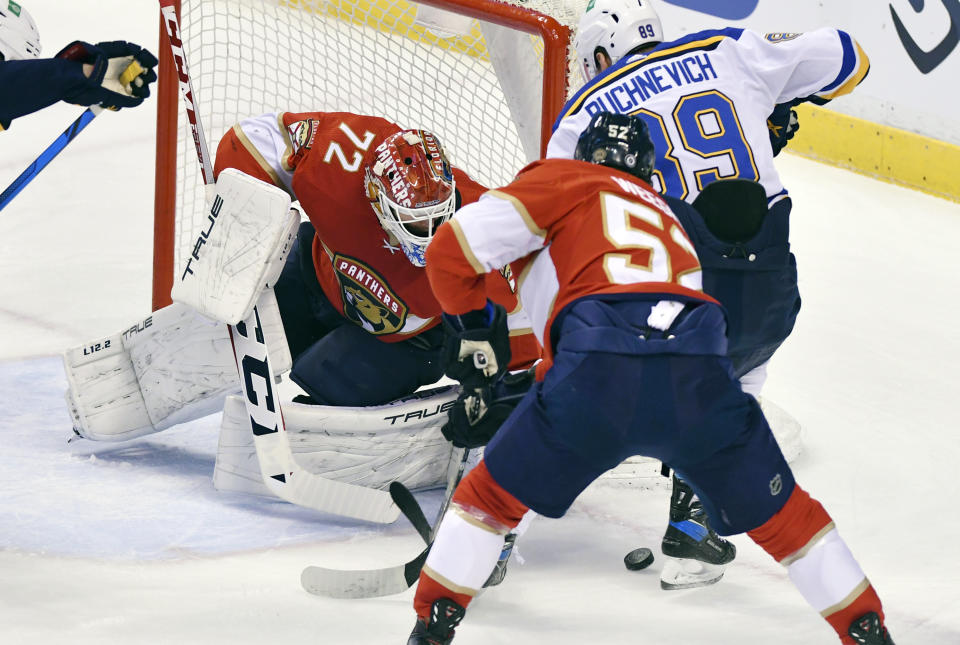Florida Panthers goaltender Sergei Bobrovsky (72) makes a save on a shot by St. Louis Blues right wing Pavel Buchnevich (89) as defenseman MacKenzie Weegar (52) follows on the play during the first period of an NHL hockey game Saturday, Dec. 4, 2021, in Sunrise, Fla. (AP Photo/Jim Rassol)