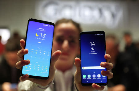 A hostess shows up Samsung's new S9 (R) and S9 Plus devices after a presentation ceremony at the Mobile World Congress in Barcelona, Spain February 25, 2018. REUTERS/Sergio Perez