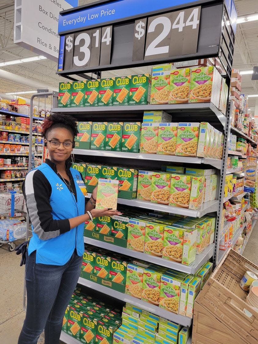 A staff member at the Coulter Walmart shows participating items customers can pick up in the store as part of the Fight Hunger. Spark Change. campaign, held in partnership with Feeding America in this 2022 file photo.