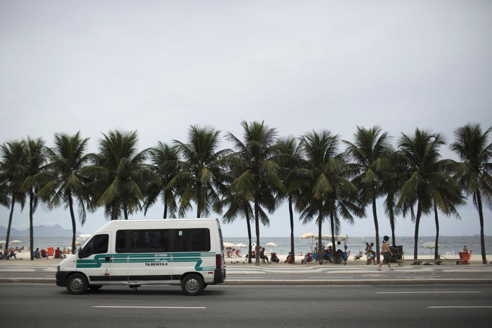 A public transport van picks up passengers along Copacabana beach in Rio de Janeiro, Brazil, Tuesday, April 2, 2013. An American woman was gang raped and beaten aboard a public transport van while her French boyfriend was shackled, hit with a crowbar and forced to watch the attacks after the pair boarded the vehicle in Rio de Janeiro's showcase Copacabana beach neighborhood, police said. The attacks took place over six hours starting shortly after midnight on Saturday. (AP Photo/Felipe Dana)