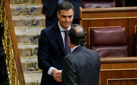 Mariano Rajoy, right, shakes hands with socialist leader Pedro Sanchez - Credit: Francisco Seco /AP