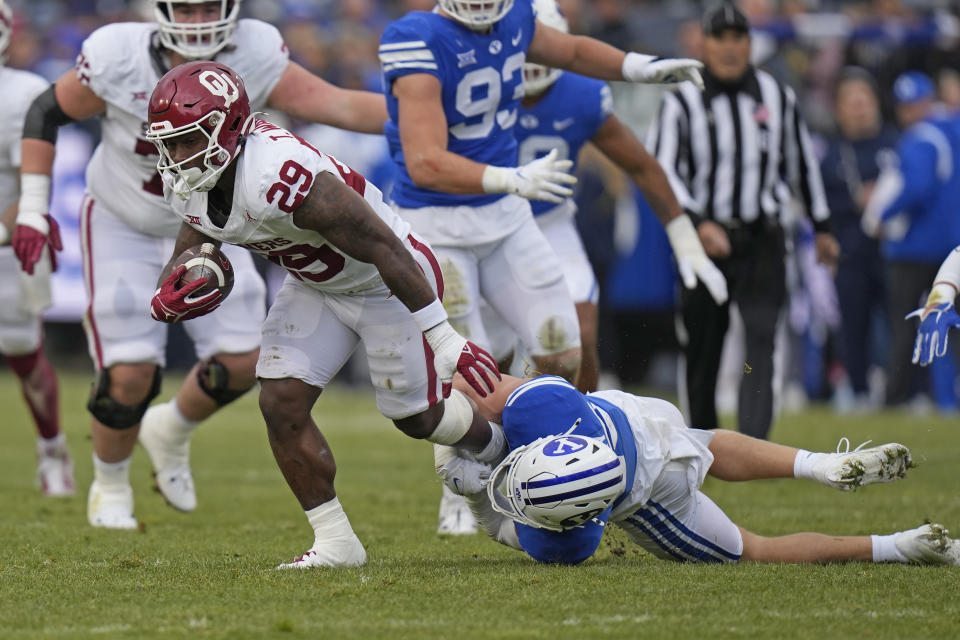 Oklahoma running back Tawee Walker (29) drags BYU safety Talan Alfrey, right, during the first half of an NCAA college football game Saturday, Nov. 18, 2023, in Provo, Utah. (AP Photo/Rick Bowmer)