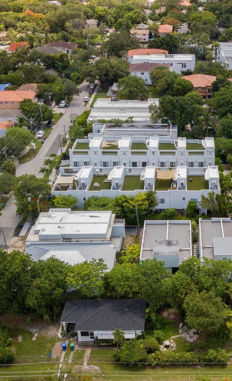 Viviendas de lujo y casas adosadas con jardines en la azotea se levantan a lo largo de lo que una vez fue una calle de casas modestas en la históricamente afroamericana West Coconut Grove, en Miami el viernes 17 de junio de 2022. La comunidad afroamericana está desapareciendo rápidamente en medio del rápido aburguesamiento.