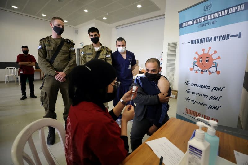 A Palestinian labourer who works within Israel or its settlements in the occupied West Bank, is vaccinated at an Israeli facility at Shaar Efraim crossing from Israel to the West Bank