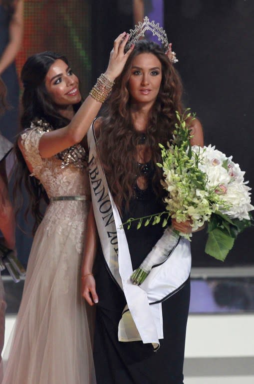 2011 Miss Lebanon Yara Khouri hands crown to Rina Shibany. AFP