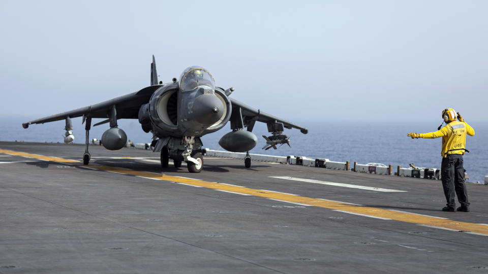 In this photo released by the U.S. Marine Corps, a sailor on the amphibious assault ship USS Bataan directs a Marine Corps AV-8B Harrier II jet in the Gulf of Oman, Monday, Aug. 14, 2023. The Bataan transited through the Strait of Hormuz, the narrow mouth of the Persian Gulf, in recent days amid tensions with Iran, U.S. Navy Cmdr. Rick Chernitzer said Sunday, Aug. 20, 2023. (Sgt. Matthew Romonoyske-Bean/U.S. Marine Corps via AP)