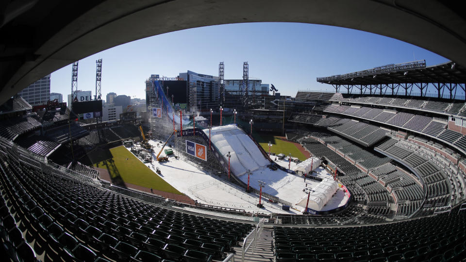 Crews work to construct and cover a giant ski slope with snow on the playing field at SunTrust Park Wednesday, Dec. 18, 2019, in Atlanta. The baseball stadium, home of the Atlanta Braves, will host the Big Air ski and snowboard competition Friday and Saturday. (AP Photo/John Bazemore)