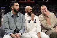 Boston Celtics starters, from left, Jayson Tatum, Derrick White and Kristaps Porzingis sit on the bench during the second half of an NBA basketball game against the Charlotte Hornets, Friday, April 12, 2024, in Boston. (AP Photo/Michael Dwyer)