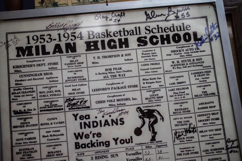 An autographed basketball schedule from the 1953-54 Milan High School basketball team hangs in the Cloverdale Barber Shop in Cloverdale, Ind., on Friday, Feb. 14, 2020. Dan Moon, the shop's owner, said he received it as a gift. u0022A lady was looking for a barber pole,u0022 he said. u0022I had an extra one and gave it to her.u0022 Months later, she returned the favor and gifted him the poster. u0022She just rolled it up and put a rubber band on it and gave it to me.u0022