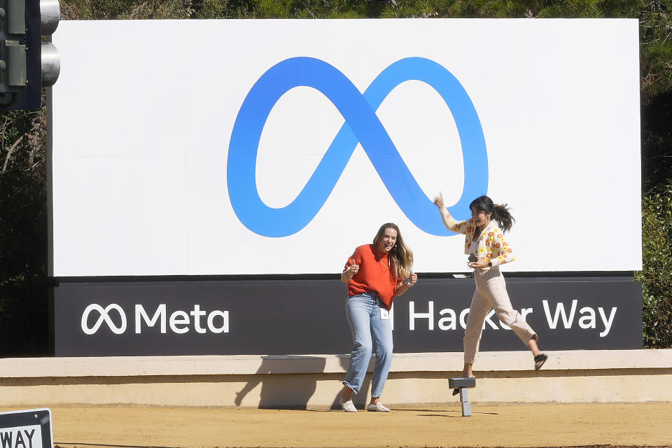 FILE - Facebook employees take a photo with the company&#39;s new name and logo outside its headquarters in Menlo Park, Calif., on Oct. 28, 2021.  Meta, the company that owns Facebook, Instagram and WhatsApp, saw its stock plunge after-hours Wednesday, Feb. 2, 2022, after reporting a rare decline in its fourth quarter profit due to a sharp increase in expenses. (AP Photo/Tony Avelar, File)