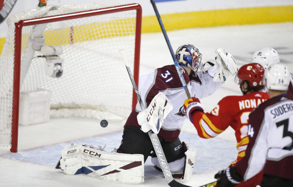 Calgary Flames center Sean Monahan (23) scores on Colorado Avalanche goaltender Philipp Grubauer (31) during the third period of Game 2 of an NHL hockey first-round playoff series Saturday, April 13, 2019, in Calgary, Alberta. (Jeff McIntosh/The Canadian Press via AP)