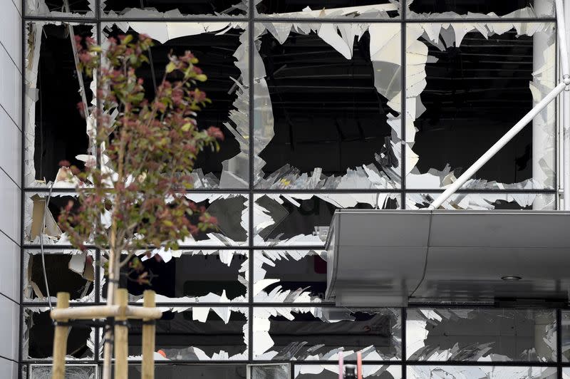 FILE PHOTO: Broken windows of the terminal at Brussels national airport are seen during a ceremony following bomb attacks in Brussels metro and Belgium's National airport of Zaventem