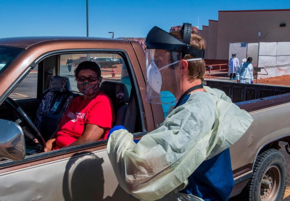 A nurse takes a swab sample from a Navajo Indian woman complaining of virus symptoms, at a testing center at the Navajo Nation town of Monument Valley in Arizona on 21 May.