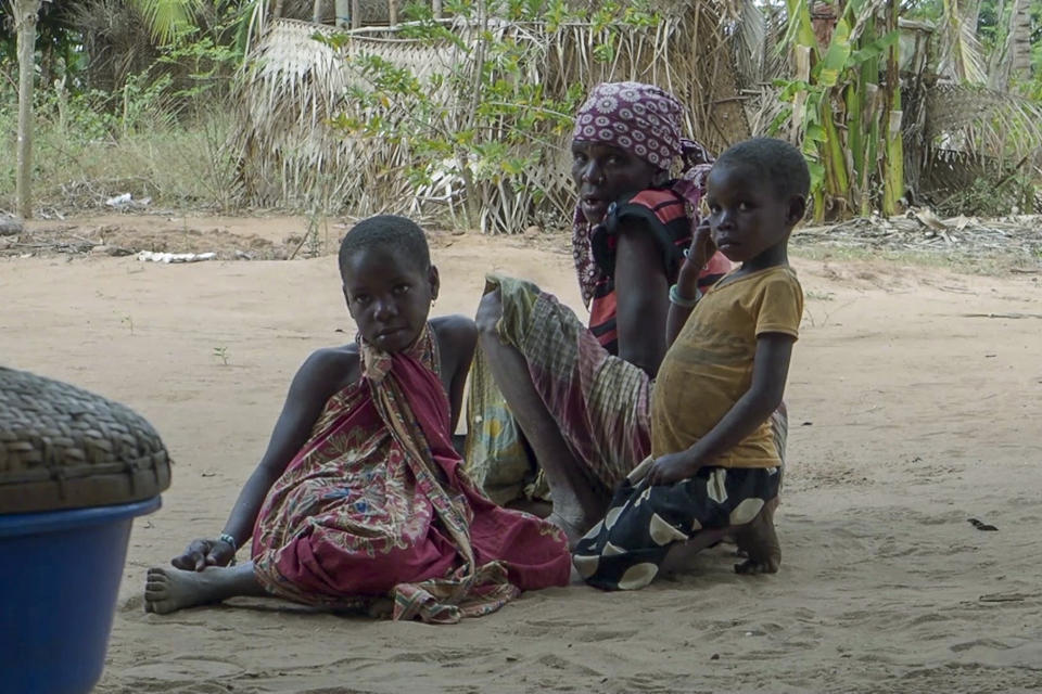 FILE - In this image made from video, residents watch as Rwandan soldiers patrol in the village of Mute, in Cabo Delgado province, Mozambique Monday, Aug. 9, 2021. Fleeing beheadings, shootings, rapes and kidnappings, nearly 1 million people are displaced by the Islamic extremist insurgency in northern Mozambique. (AP Photo/Marc Hoogsteyns, File)