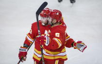 Calgary Flames' Mark Giordano, right, celebrates his goal with teammate Sam Bennett during third-period NHL hockey game action against the Vancouver Canucks in Calgary, Alberta, Monday, Jan. 18, 2021. (Jeff McIntosh/The Canadian Press via AP)