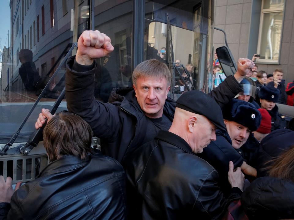 An opposition supporter gestures as he blocks a police van transporting detained anti-corruption campaigner and opposition figure Alexei Navalny during a rally in Moscow, Russia, March 26, 2017.