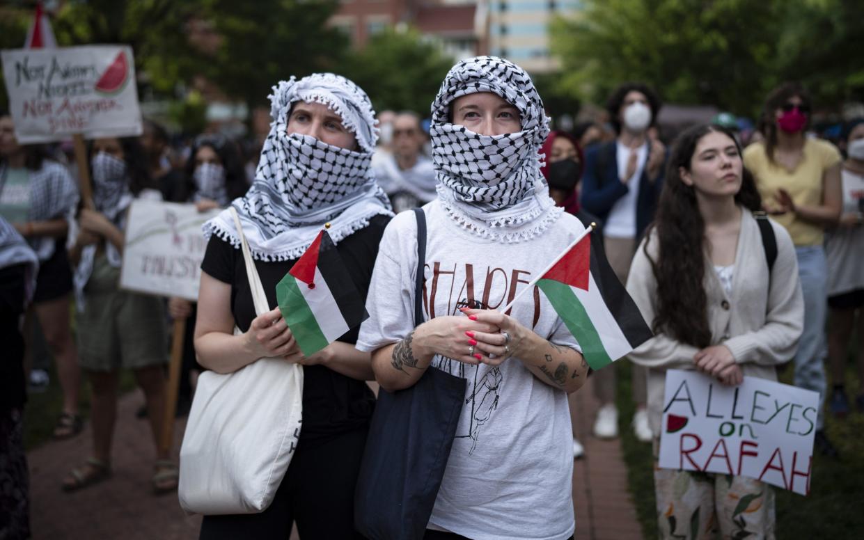Students hold Palestinian flags as they continue pro-Palestinian demonstrations at George Washington University