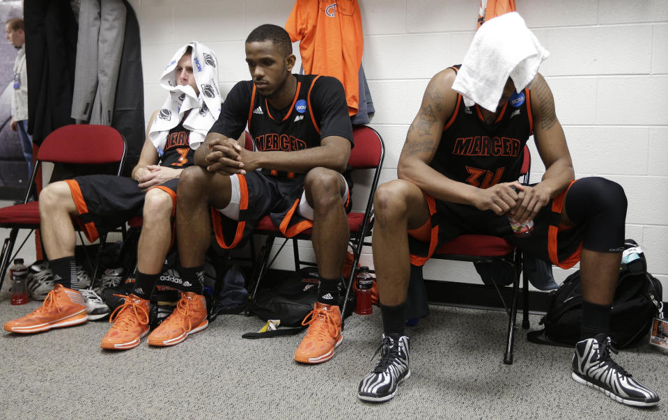 Mercer's Kevin Canevari, Darious Moten, and Jibri Bryan sit in the locker room after the second half of an NCAA college basketball third-round tournament game against Tennessee, Sunday, March 23, 2014, in Raleigh. Tennessee Won 83-63. (AP Photo/Chuck Burton)