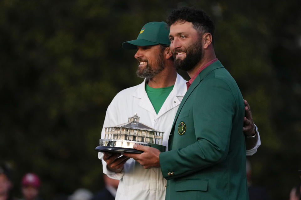 Jon Rahm, of Spain, poses for a photo with his caddie Adam Hayes holding the trophy after winning the Masters golf tournament at Augusta National Golf Club on Sunday, April 9, 2023, in Augusta, Ga. (AP Photo/Jae C. Hong)