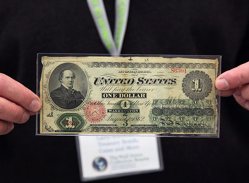 Collector Larry Schuffman holds up a United States One Dollar note that was printed in 1862.