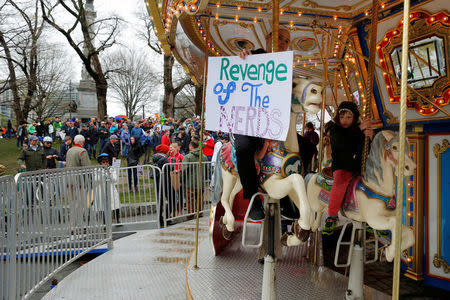 A demonstrator rides the carousel at the March for Science rally on the Common in Boston, Massachusetts, U.S., April 22, 2017. REUTERS/Brian Snyder