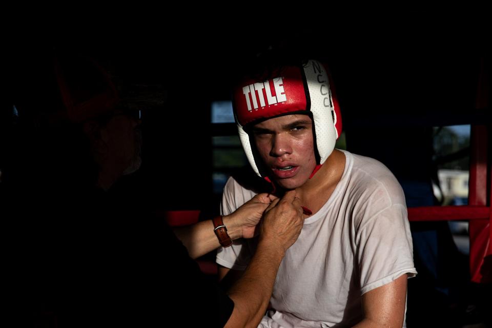 Antonio Clark, 15, catches his breath after sparring at Gollihar Neighborhood Boxing Center on July 27, 2023, in Corpus Christi, Texas. Christian Perez, a professional boxer said, boxing "teaches you how to be responsible for yourself. It teaches you how to push through, persevere when you feel like you're bogged down a little bit."