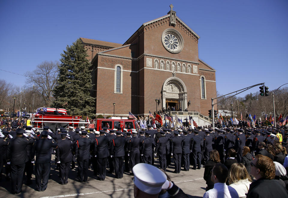 The funeral procession for Boston firefighter Michael R. Kennedy proceeds through saluting firefighters as it arrives at Holy Name Church in Boston, Thursday, April 3, 2014. Kennedy and Boston Fire Lt. Edward J. Walsh were killed Wednesday, March 26, 2014 when they were trapped in the basement of a burning brownstone during a nine-alarm blaze.(AP Photo/Stephan Savoia)