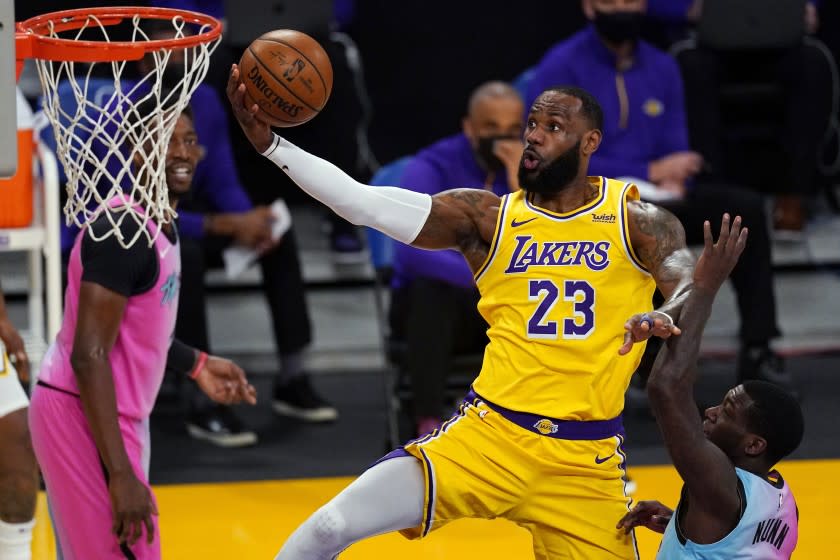 Los Angeles Lakers forward LeBron James shoots as Miami Heat guard Kendrick Nunn.