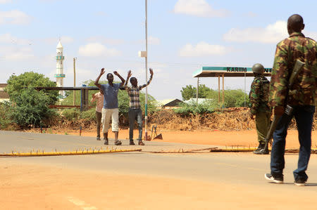 Security officers question civilians at a roadblock near the scene where gunmen abducted two Cuban doctors as they were going to work, in Mandera county, Kenya April 12, 2019. REUTERS/Stringer