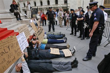 Police stand in front of Occupy Wall Street activists staging a protest in New York in this April 20, 2012 file photo. REUTERS/Eduardo Munoz/Files