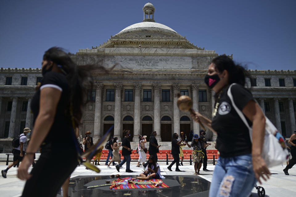 A group of activists march demanding statues and street names commemorating symbols of colonial oppression be removed, in San Juan, Puerto Rico, Saturday, July 11, 2020. Dozens of activists marched through the historic part of Puerto Rico’s capital on Saturday to demand that the U.S. territory’s government start by removing statues, including those of explorer Christopher Columbus. (AP Photo/Carlos Giusti)