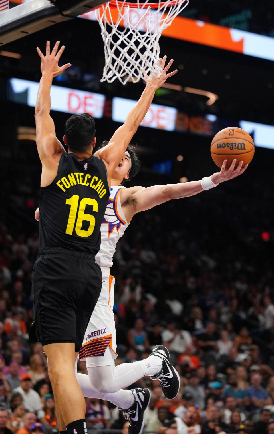 October 28, 2023; Phoenix, Ariz.; USA; Suns forward Yuta Watanabe makes a layup against Jazz forward Simone Fontecchio (16) during the second half of the home opener at the Footprint Center.