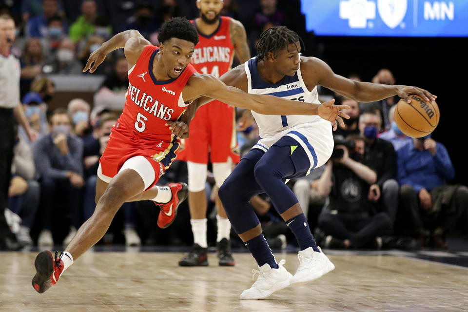 New Orleans Pelicans guard Devonte' Graham (4) and Timberwolves forward Anthony Edwards (1) reach for thse ball in the first half of an NBA basketball game, Monday, Oct. 25, 2021, in Minneapolis. (AP Photo/Andy Clayton-King)