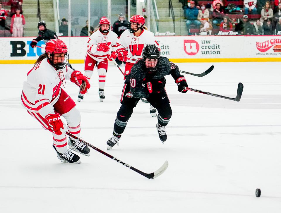 Wisconsin defenseman Nicole LaMantia (21) and Ohio State forward Makenna Webster (20) rush toward the puck during the second period Saturday February 18, 2023 at LaBahn Arena in Madison, Wis.