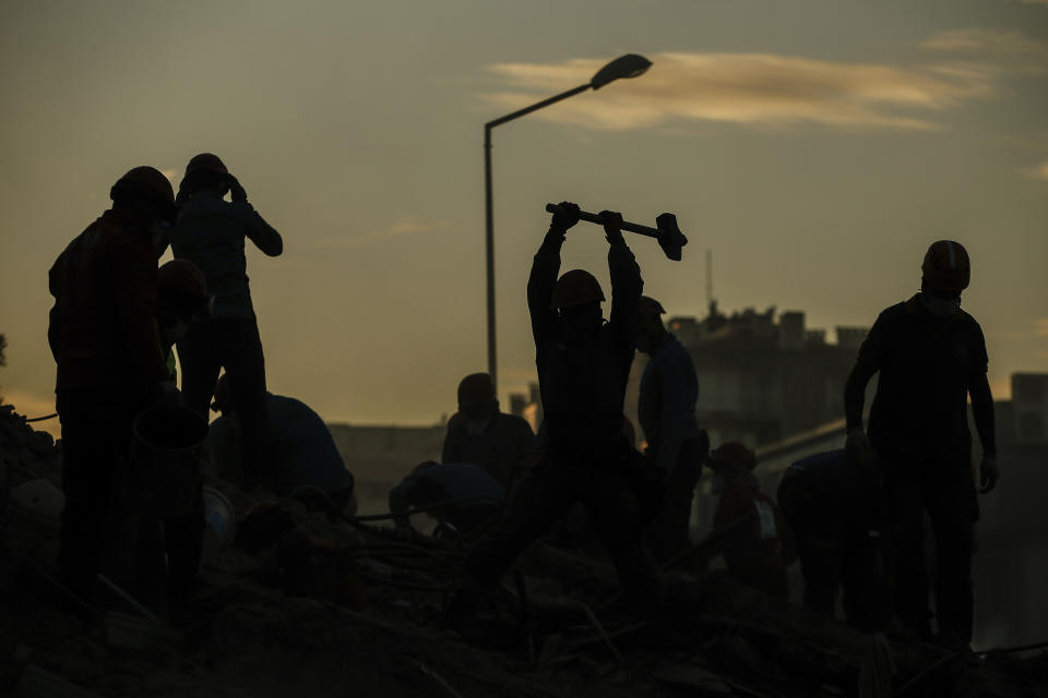 Members of rescue services search for survivors in the debris of a collapsed building in Izmir, Turkey, Monday, Nov. 2, 2020. In scenes that captured Turkey's emotional roller-coaster after a deadly earthquake, rescue workers dug two girls out alive Monday from the rubble of collapsed apartment buildings three days after the region was jolted by quake that killed scores of people. Close to a thousand people were injured. (AP Photo/Emrah Gurel)