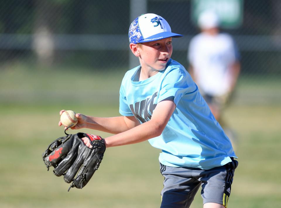 Henry Schmitz (#18) winds up to throw from third base to home during Little League practice on Monday, August 1, 2022, at Cherry Rock Park in Sioux Falls.