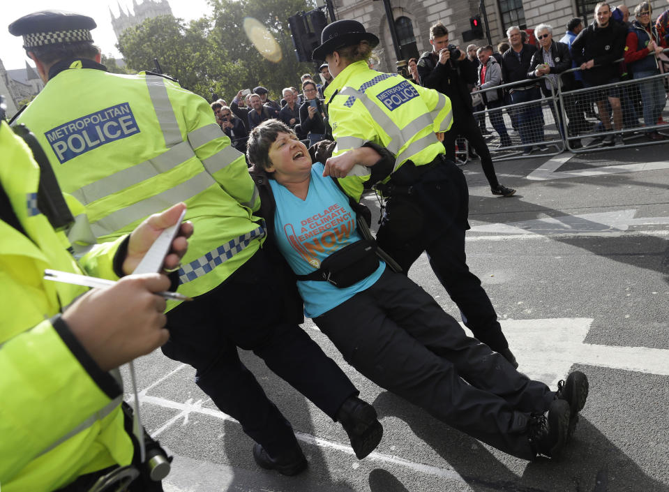 Police arrest a climate demonstrator on Whitehall in London, Tuesday, Oct. 8, 2019. Police are reporting they have arrested more than 300 people at the start of two weeks of protests as the Extinction Rebellion group attempts to draw attention to global warming. (AP Photo/Kirsty Wigglesworth)