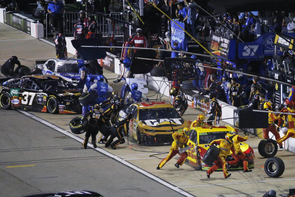 Joey Logano, right, and others make pit stops during the NASCAR Cup Series auto race at Richmond Raceway in Richmond, Va., Saturday, Sept. 21, 2019. (AP Photo/Steve Helber)