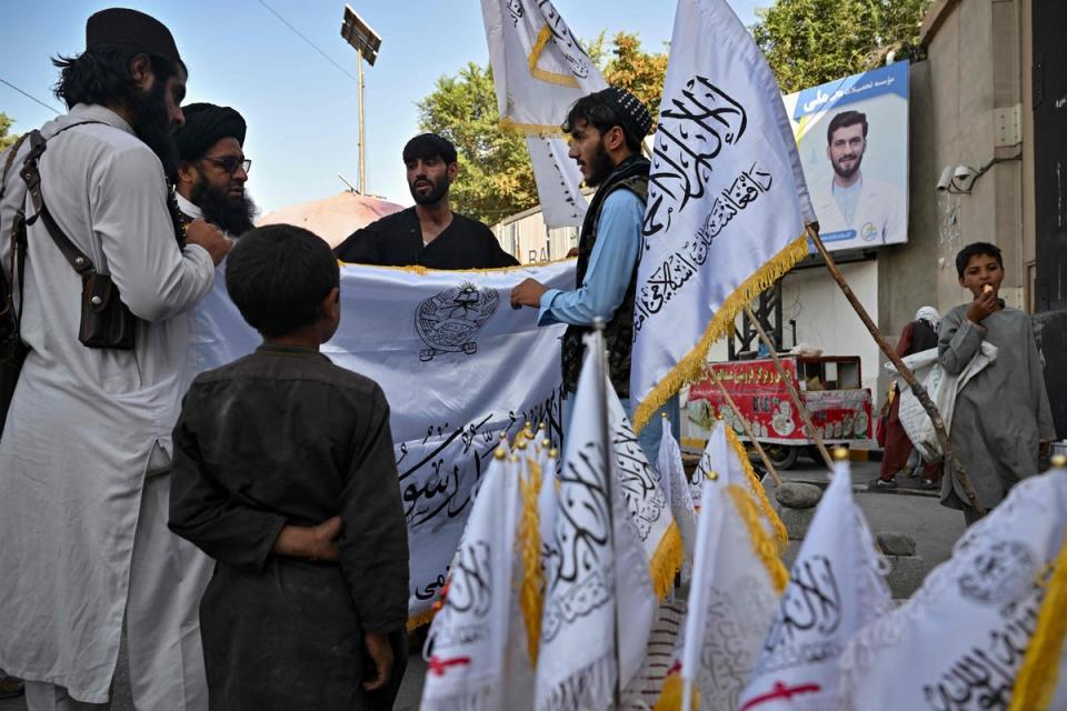 Men buy Taliban flags along a street in Kabul (AFP via Getty Images)