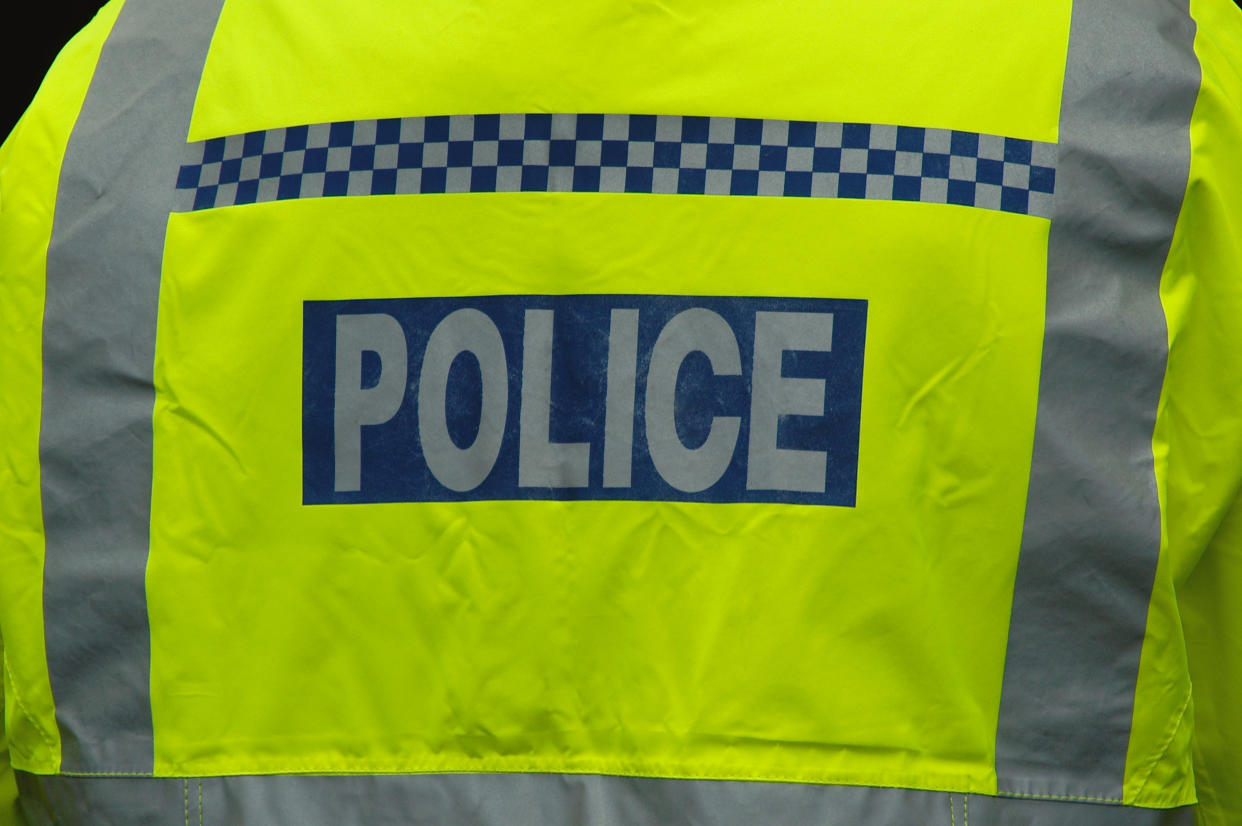 Close-up of a London police officer wearing a high visibility jacket, shot from behind.