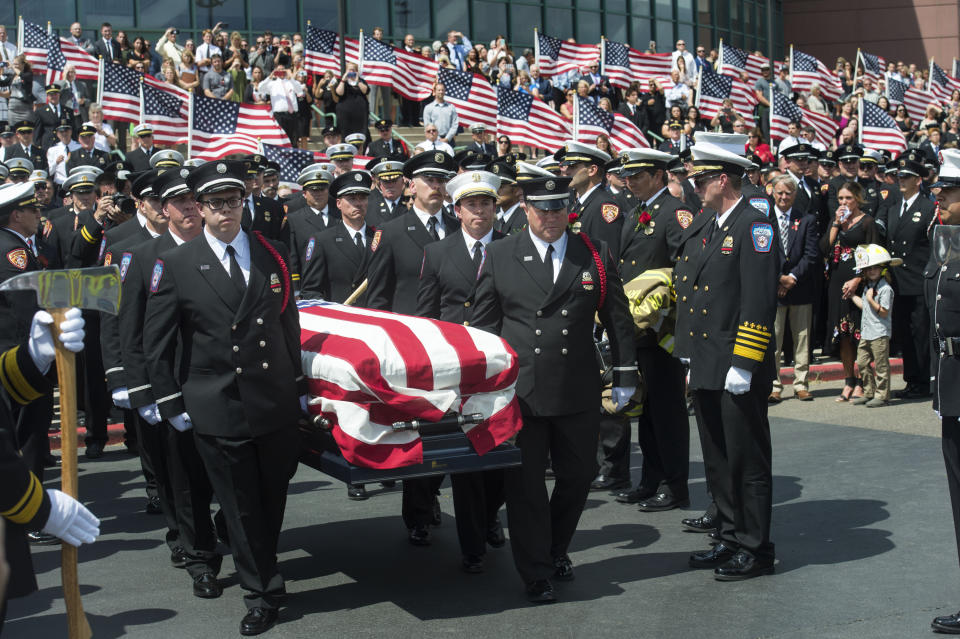 FILE - In this Aug. 20, 2018, file photo, the casket with fallen Utah firefighter Matthew Burchett is loaded into a fire engine after the funeral at the Maverik Center in West Valley City, Utah. Burchett, a firefighter battling the largest wildfire in California history, was killed last month when thousands of gallons of flame-suppressing liquid were dropped from a Boeing 747 that was mistakenly flying only 100 feet (30 meters) above the treetops, according to an official report Friday, Sept. 14. (Rick Egan/The Salt Lake Tribune via AP, File)