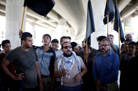 Shop owners and workers chant slogans during a strike called by local activists against U.S. President Donald Trump's "Deal of the Century" at Al-Baqaa Palestinian refugee camp